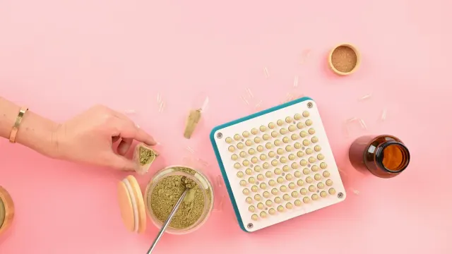 Owner spooning a fine herbal supplement powder over a dog's food bowl